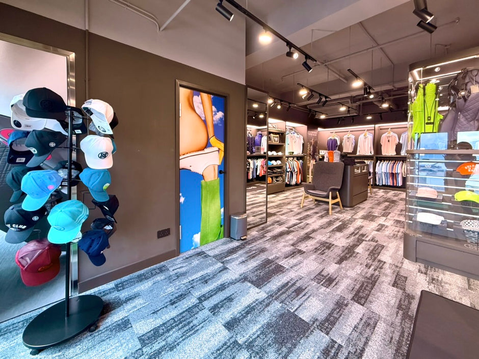 Interior of a clothing store with hats on display and various items on shelves.