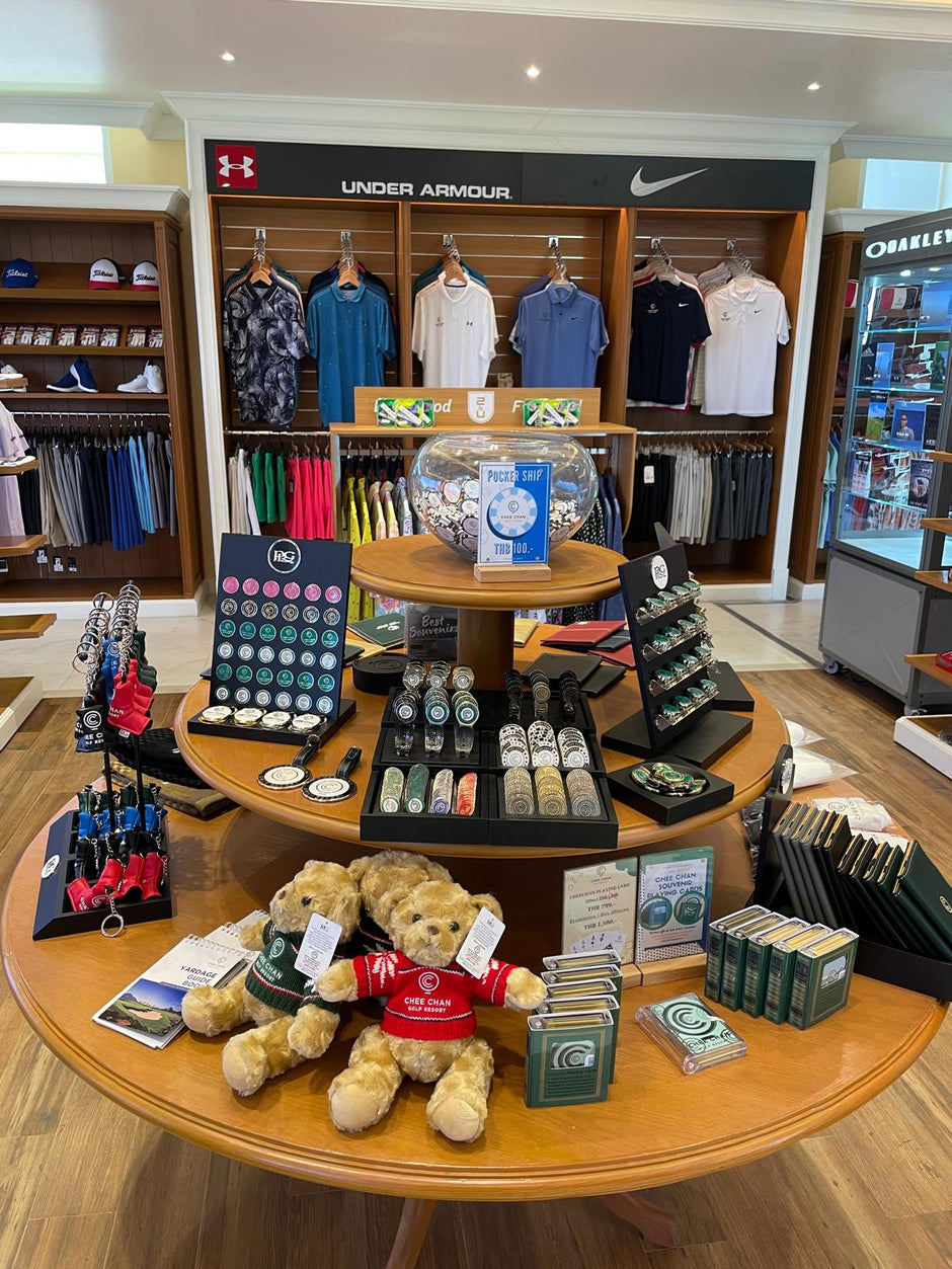 Display of Under Armour and Nike clothing with accessories on a wooden table.