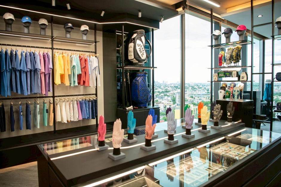 Display of colorful clothing and accessories in a high-rise store with cityscape view